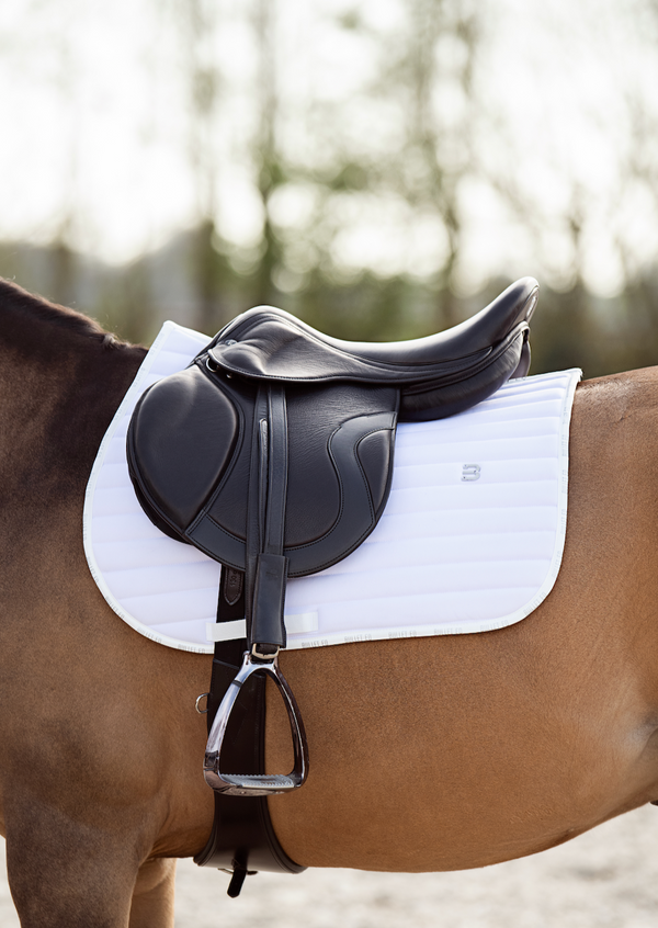 white saddle pad jumping