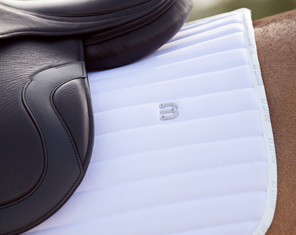 white saddle pad jumping